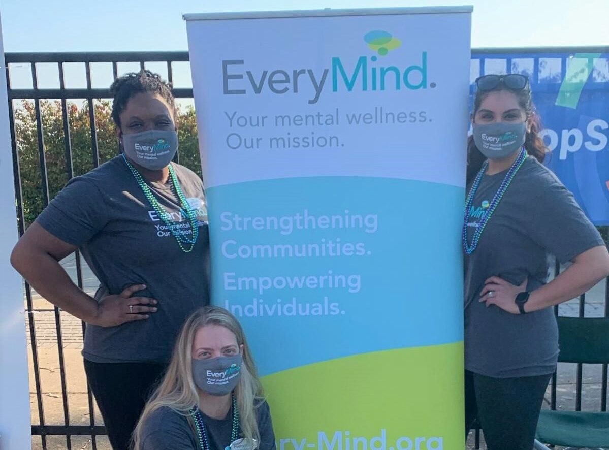 three EveryMind volunteers at an outdoor event advertising mental health services