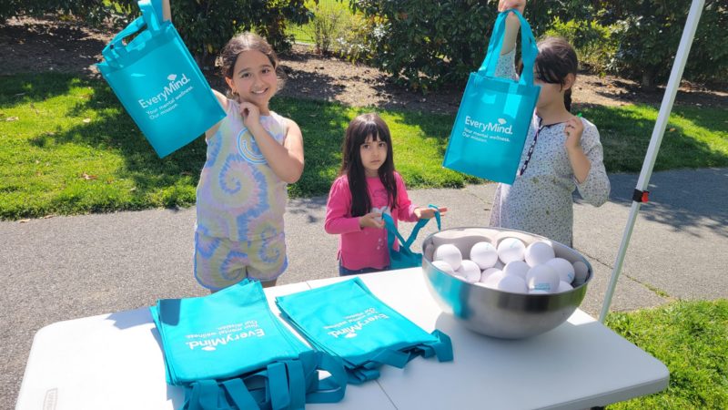 Montgomery County resources for mental health: Three girls hold up swag bags at an EveryMind event.