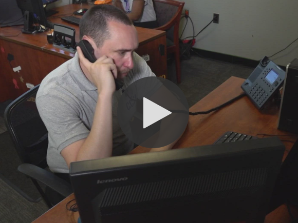 Video Screenshot of man answering phone: 988 Hotline Marks One Year of Helping People in Crisis
