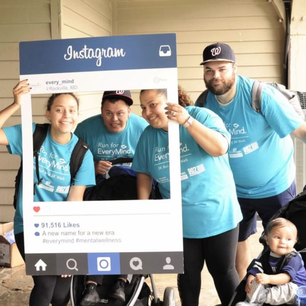 Family of 5 pose in an Instagram frame wearing blue EveryMind shirts for a photo
