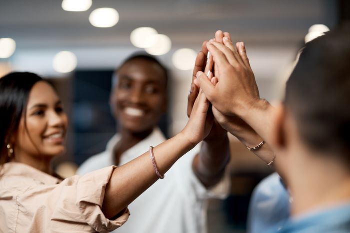 Internships in mental health: a group of young people high five.