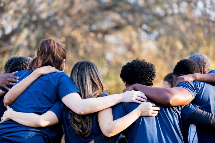 EveryMind volunteers huddle together after a job well done in a group hug.