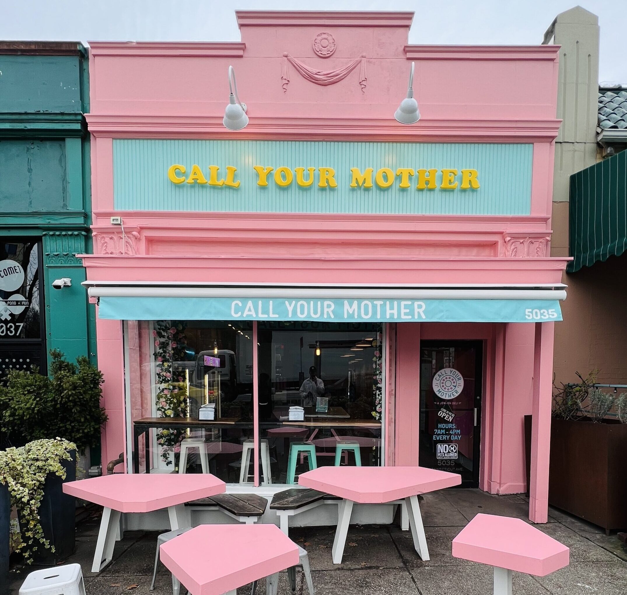Pink Building with outside seating sign reads Call Your Mother